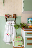 Vintage kitchen area with hand-embroidered tea towel and retro tins