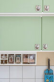 Green kitchen cabinets with practical storage containers