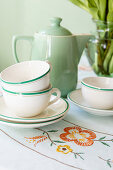 Vintage crockery from the 1940s with floral embroidery on the tablecloth