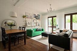 Open-plan living area with green sofa and picture gallery on the wall