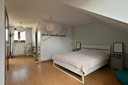Bedroom with wooden floor and sloping ceiling