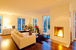 Moderne Wohnung mit Weihnachtsbaum, Frau mit Päckchen, Hamburg, Deutschland