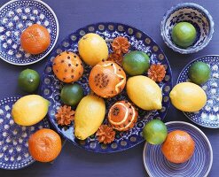 Still life with clove-studded oranges & other citrus fruit