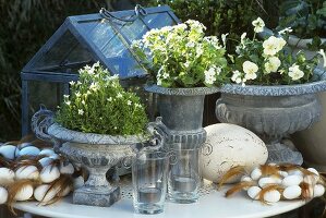 Easter decorations in garden: romantic flowerpots, eggs, feathers