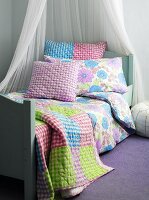 Bed with canopy, bedspread and cushions