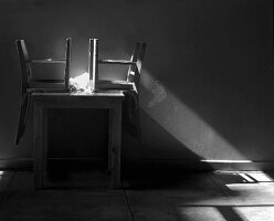 Sunlight Shining on Two Chairs Overturned on a Table