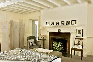 Klassisch elegantes Schlafzimmer mit altem Kamin und weisser Holzbalkendecke