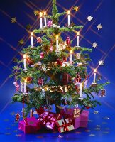 Geschmückter Weihnachtsbaum mit Kerzen und Geschenken