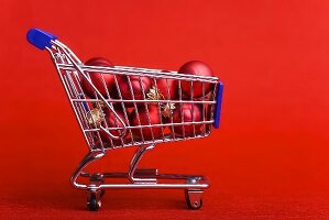 Red Christmas baubles in shopping trolley