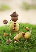 Dog and man made from acorn cups, acorns and crab apples