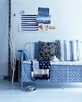 Blue and white cushions and blankers on a metal bench cushions and blankets