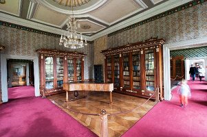 The library at Corvey – a harpsichord and antique cabinets with intarsia in a cordoned-off section with herringbone parquet flooring, for visitors a deep pink carpet