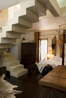 Floating concrete staircase in modern living room with dark wooden floor