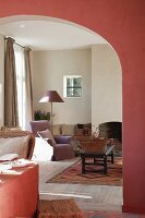 Lachsrote Wand im Esszimmer mit breitem Rundbogen und Blick in das