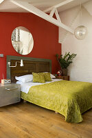 Bedroom with green bed linen and red accent wall