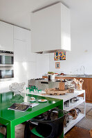 Modern kitchenette with green dining table and stainless steel appliances