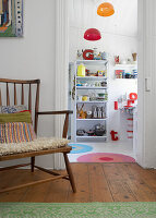 View of kitchen with colourful accent lamps and white shelf full of kitchen utensils