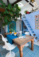 Wooden table with blue table runner, monstera and blue wooden ladder