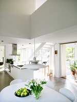 Modern kitchen with white interior and tulips on the table