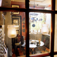 View through window to small kitchen with vintage decorations and pendant lights