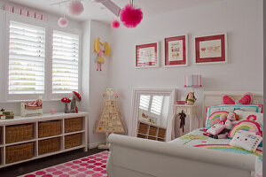 Girls' room in white and pink with bed and toy storage