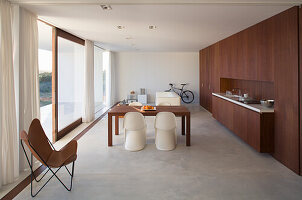 Modern open-plan kitchen with dining table and minimalist furnishings