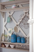 Vintage shelf with decorative items and blue kitchen canisters on the wall