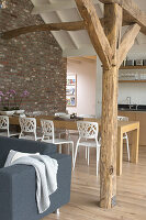 Open-plan kitchen with dining area, wooden beams and brick wall