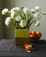 White Ranuncula Arrangement in a Square Vase; Mandarin Oranges