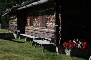 Alte Berghütte mit Geranien auf der Alm