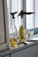 Oil bottles with decorative driftwood stoppers on a windowsill