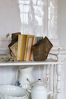 Shelf with crockery, books and bookends made of rustic wood