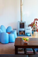 Pastel blue log burner and unusual upholstered armchair shaped like a flower