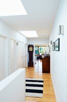 Bright hallway with black and white rug and antique grandfather clock