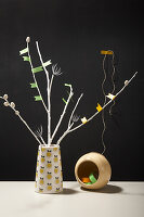 White branches with colorful DIY flags in a vase