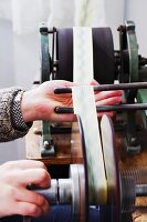 Fabric ribbon being wound onto spool by machine
