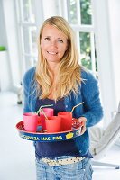 Mother serving tray of drinks in plastic beakers