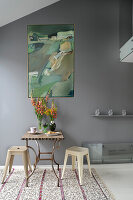 Small dining area, with modern painting on grey wall