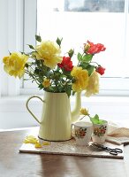 Bouquet of roses in jug in front of window