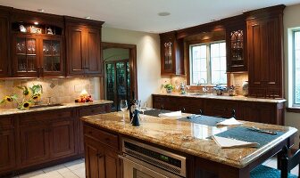 Country kitchen with solid wooden cupboard doors and free-standing island with stone worksurface