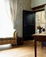Eingangsbereich mit offener Haustür in traditionellem, französischen Landhaus aus Naturstein