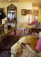 Yellow, Baroque-style living room with ornate wall mirror and gilt coffee table with glass top