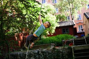 Little boy climbing a rope
