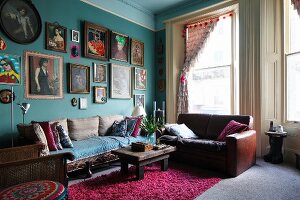 Many different framed pictures of women on turquoise wall in vintage-style period apartment