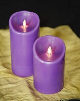 two purple candles on a yellow cloth