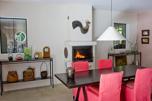 Wooden table with red chairs and fireplace in the dining room