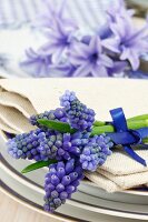 Place setting decoration with grape hyacinth (Muscari) on a linen serviette