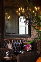 Detail of hotel restaurant with leather sofa, mirror on wall and chandelier