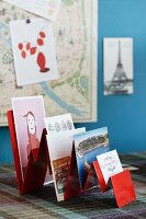 Various postcards in red-painted rack