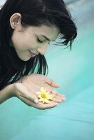 Young woman holding flowers in cupped hands